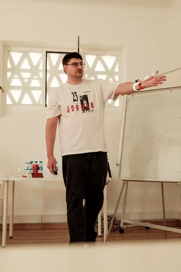 A speaker pointing at the whiteboard